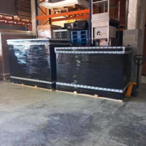 Two wrapped cardboard liftvans on pallets in a warehouse.