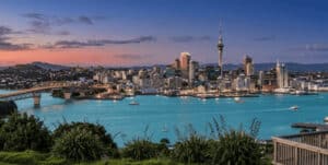 Skyline of Auckland city and Waitematā Harbour at twilight, featuring the Sky Tower