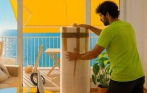 Operario de Wisse Moving embalando cuidadosamente un mueble con material protector para una mudanza internacional.